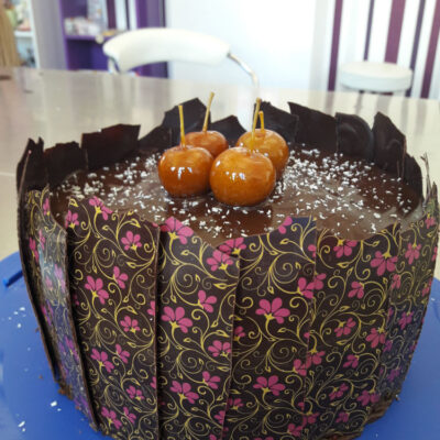 Schokoladentorte mit karamelisierten Äpfeln umhüllt mit Schokoladendekor mit Blumenmotiv